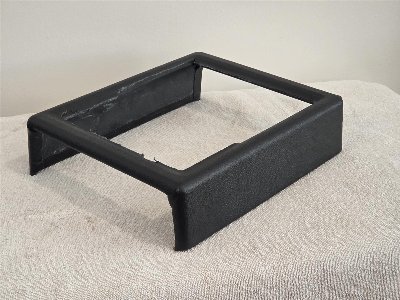 Reproduction Fiero center console frame wrapped in black vinyl