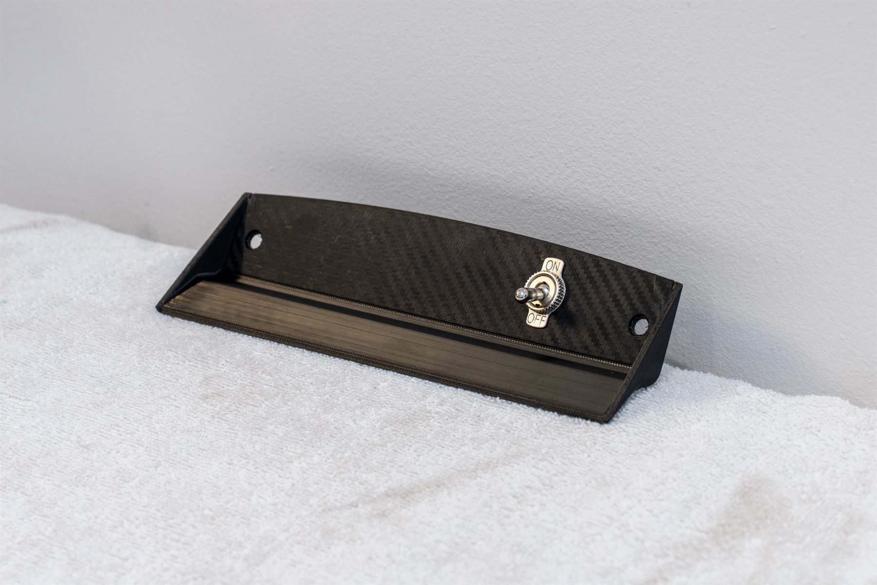 Reproduction Fiero lighter bezel with a toggle switch, in the carbon weave finish