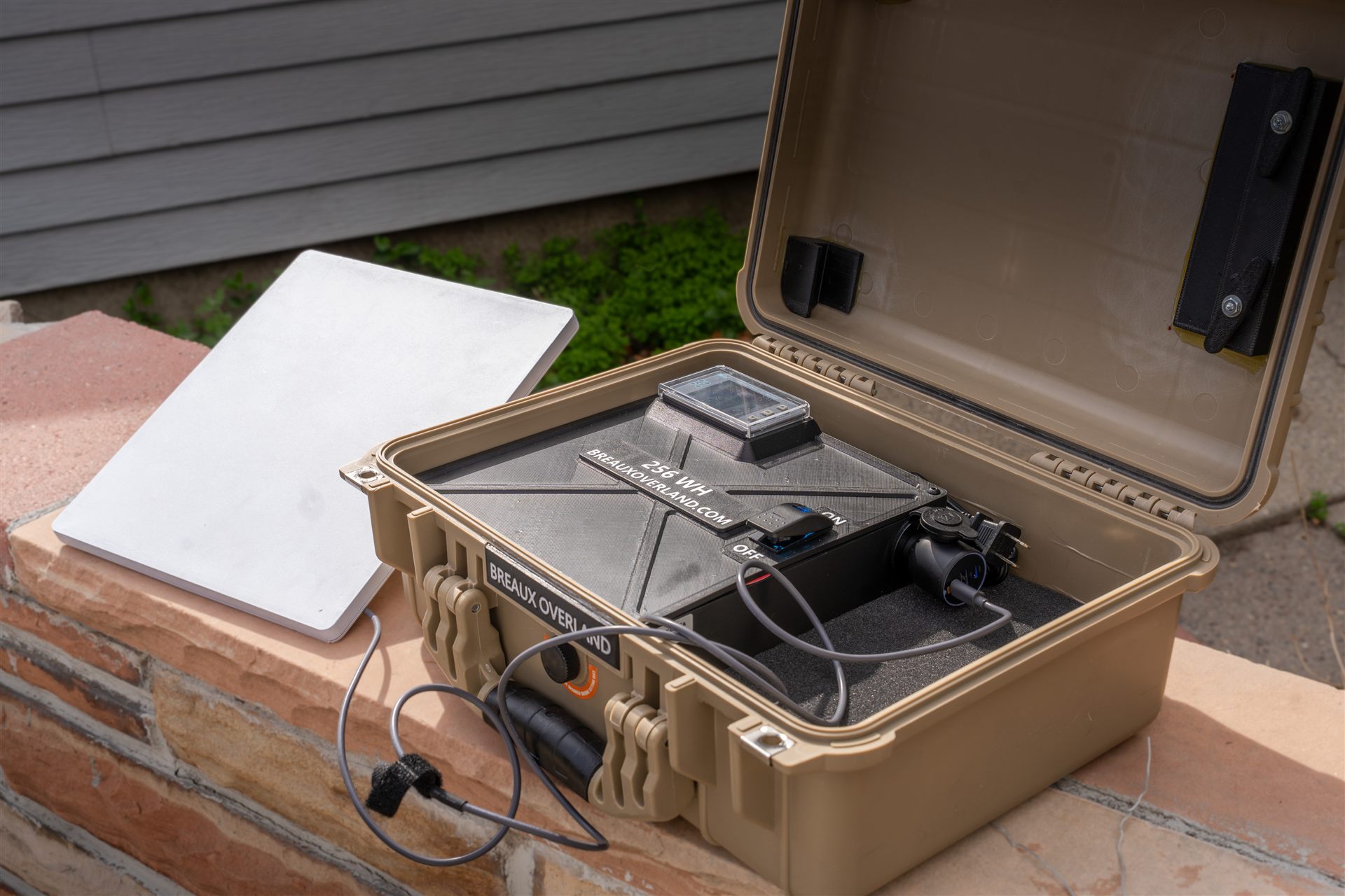 Starlink rental case open with the battery box switched on, powering the Starlink Mini set beside it